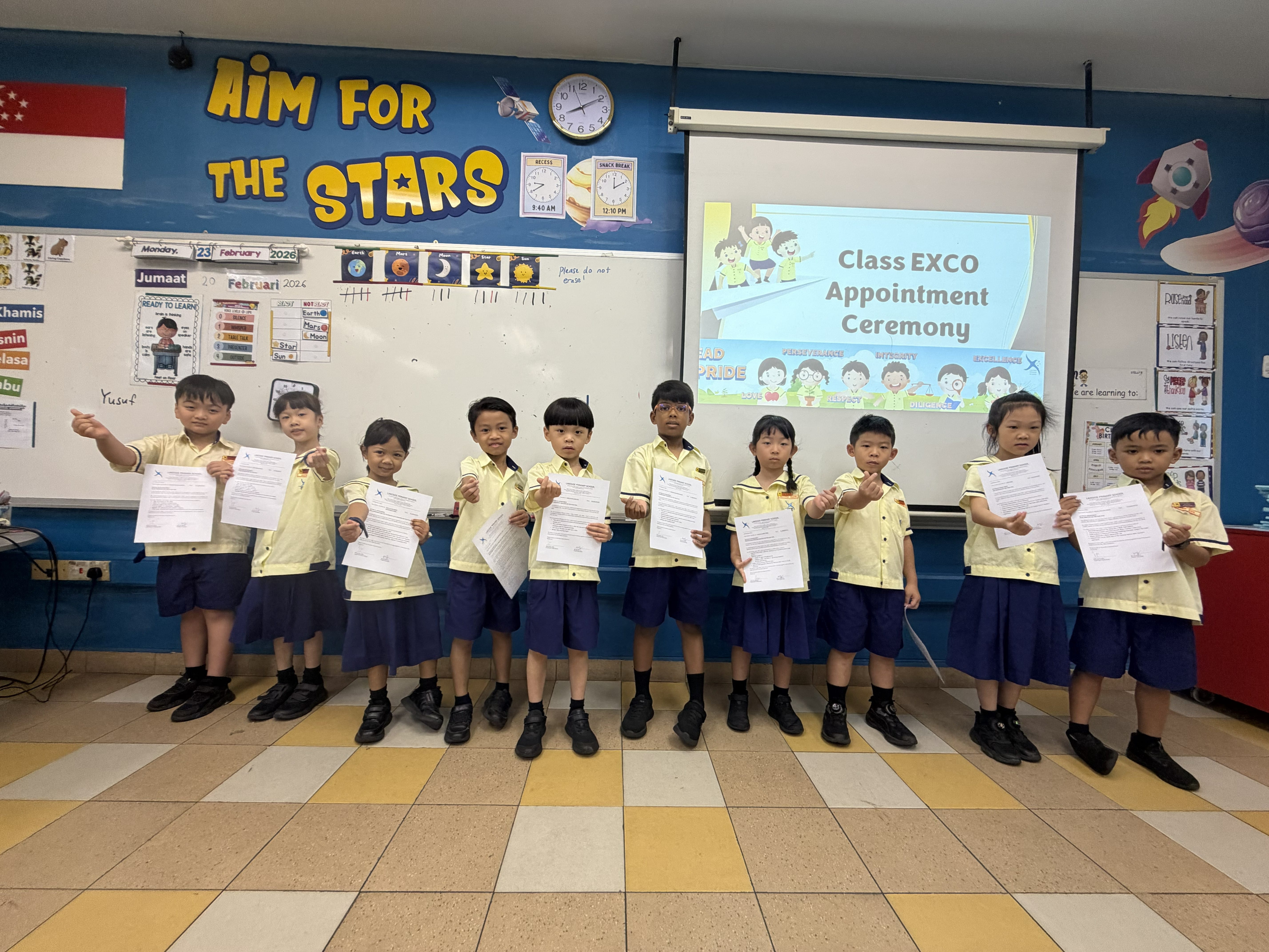 Newly appointed Class EXCO members pose for a photo in front of the class with their certificates of appointments